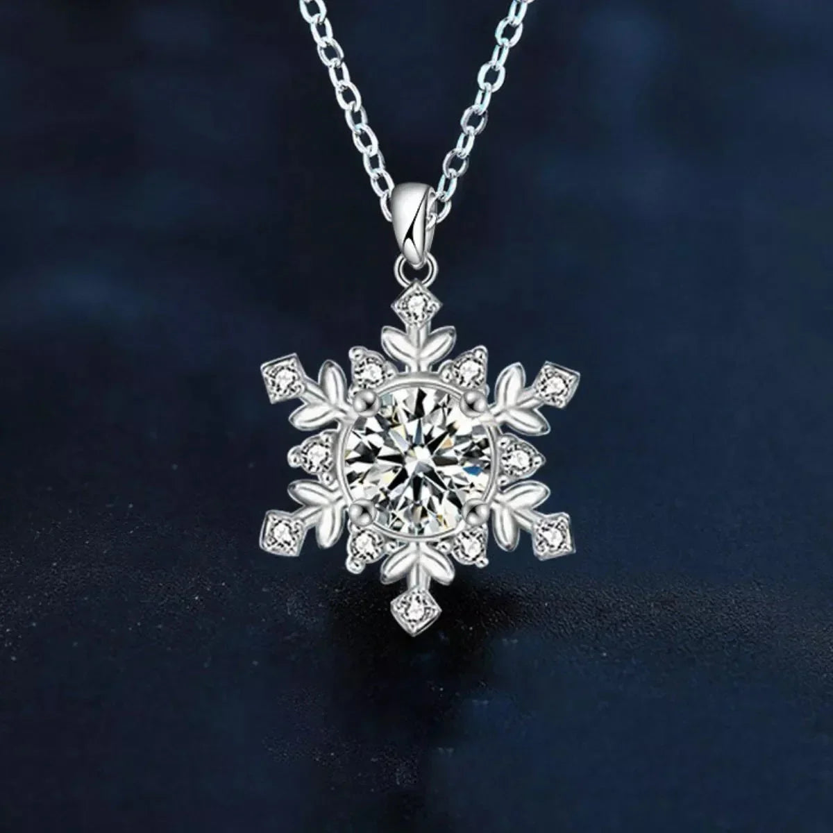 Silver snowflake pendant necklace with crystal center on dark background, Qu!rk Boutique jewelry.
