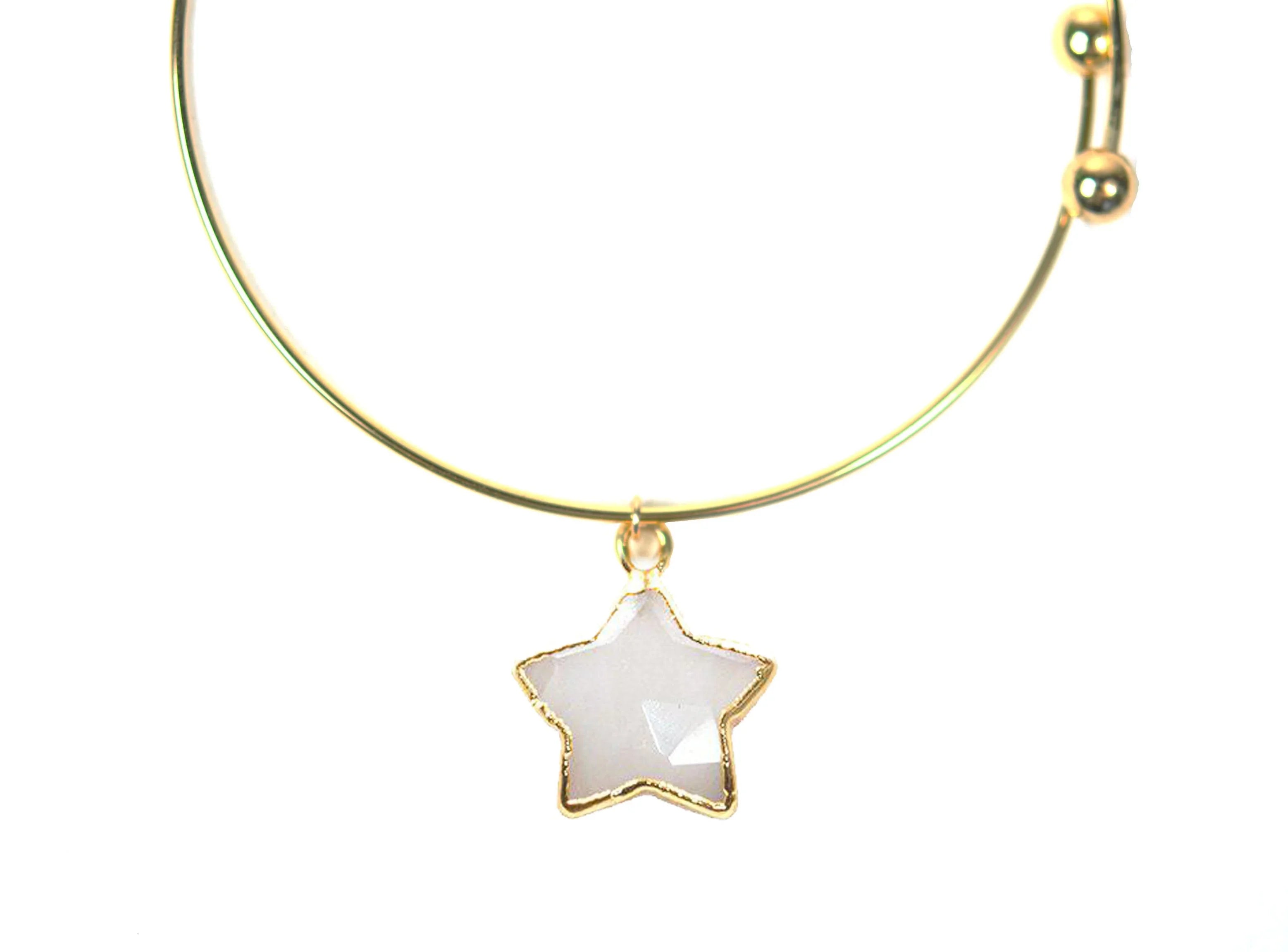 Gold bangle bracelet with a star-shaped moonstone charm on white background