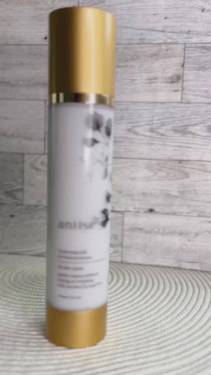 Gold and white skincare bottle on textured surface at Qu!rk Boutique, artist-designed gift shop.