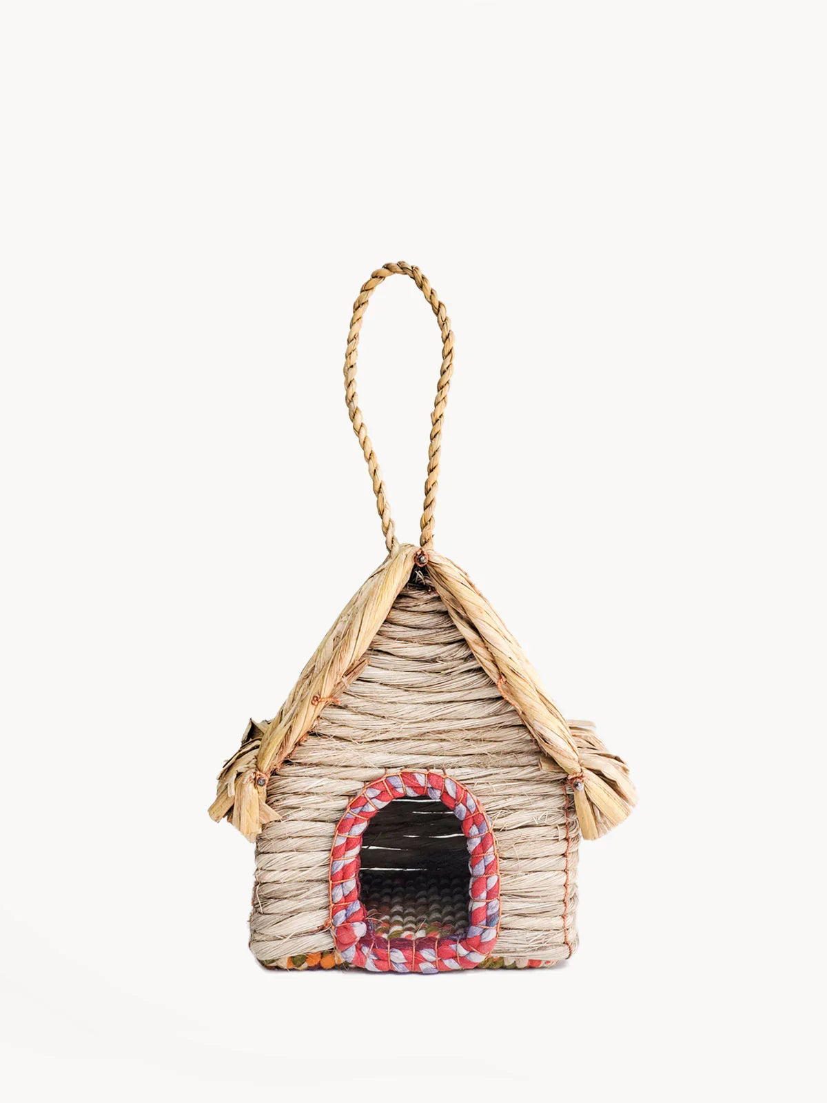Small birdhouse cabin woven from natural straw with colorful fabric trim and hanging loop