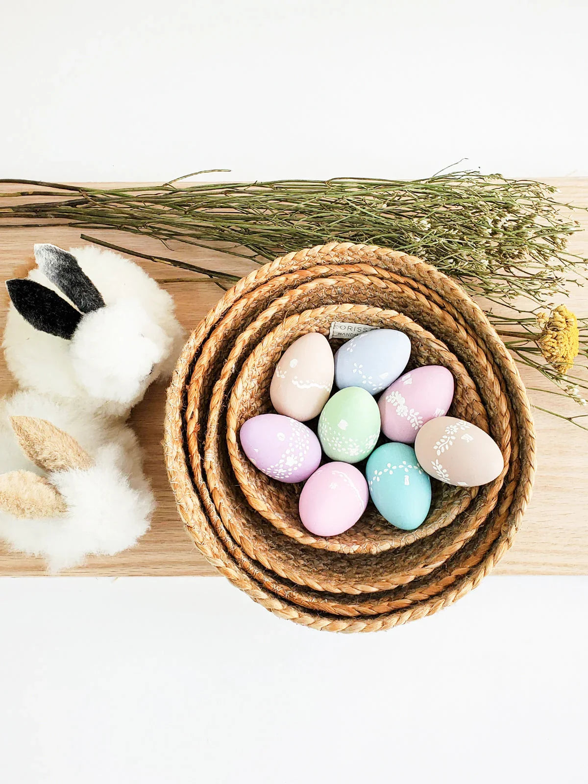 Pastel Easter eggs in woven baskets with felt bunny decor and dried flowers, Qu!rk Boutique