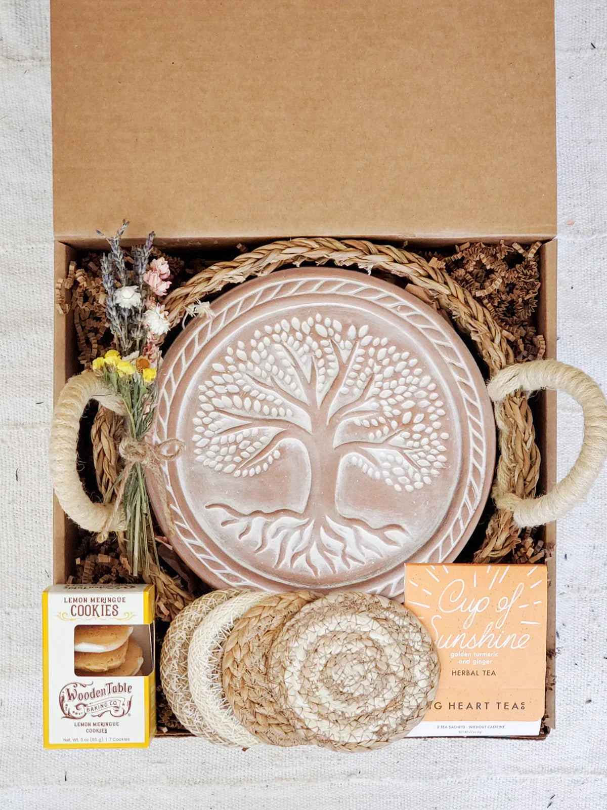 Gift box with ceramic tree embossed bread warmer, coasters, herbal tea, lemon cookies, and dried flowers