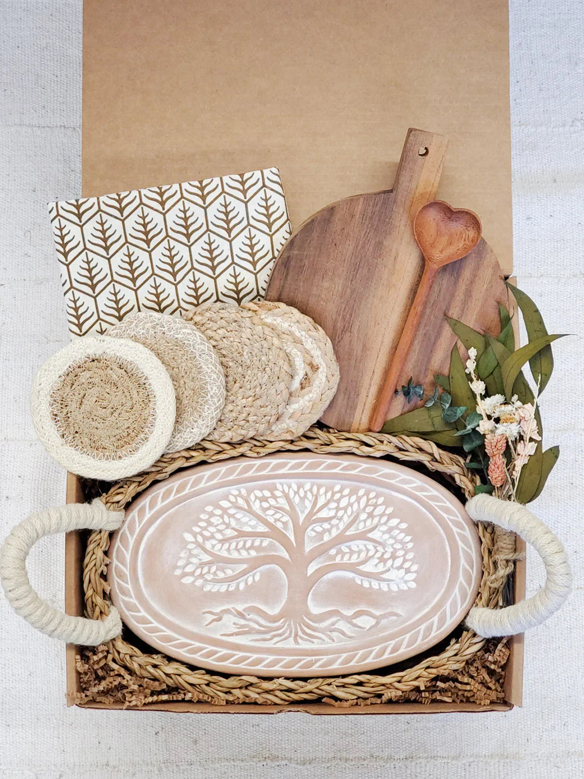 Eco-friendly gift box with carved tree platter, wooden heart spoon, coasters, cloth napkin, and dried flowers
