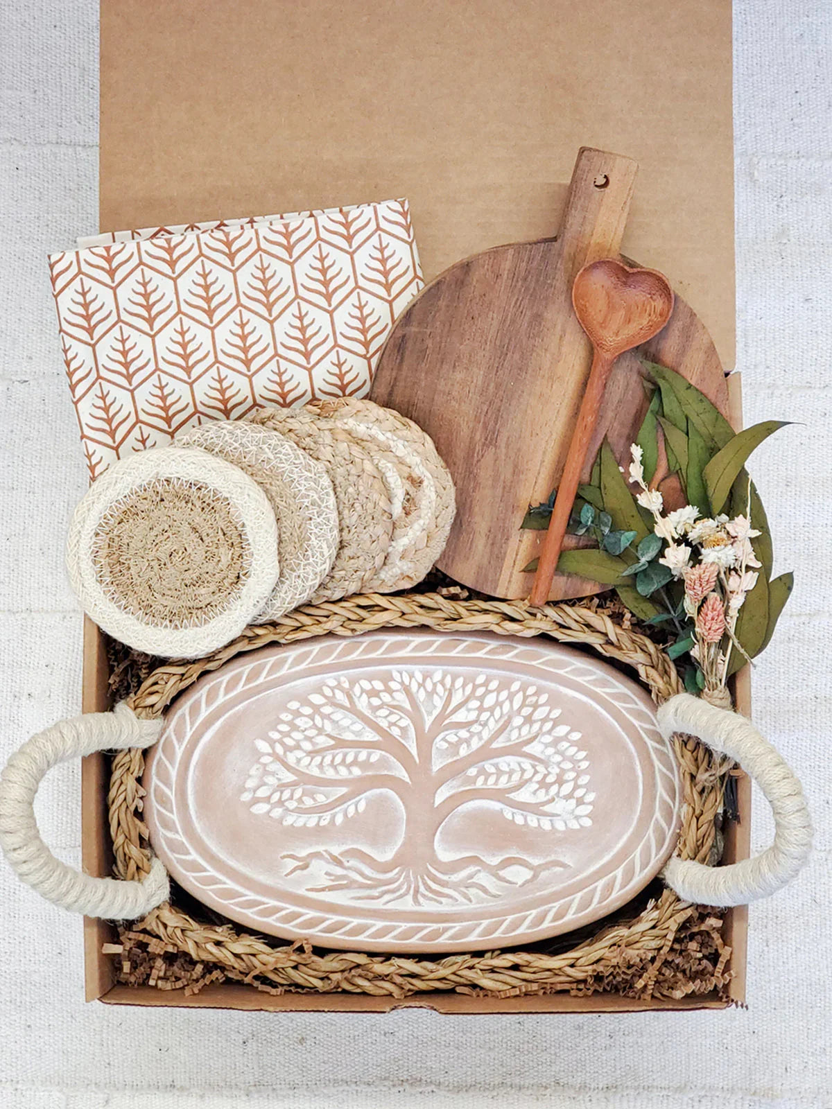 Gift box with carved bread warmer tray, wooden cutting board, heart spoon, coasters, and dried flowers
