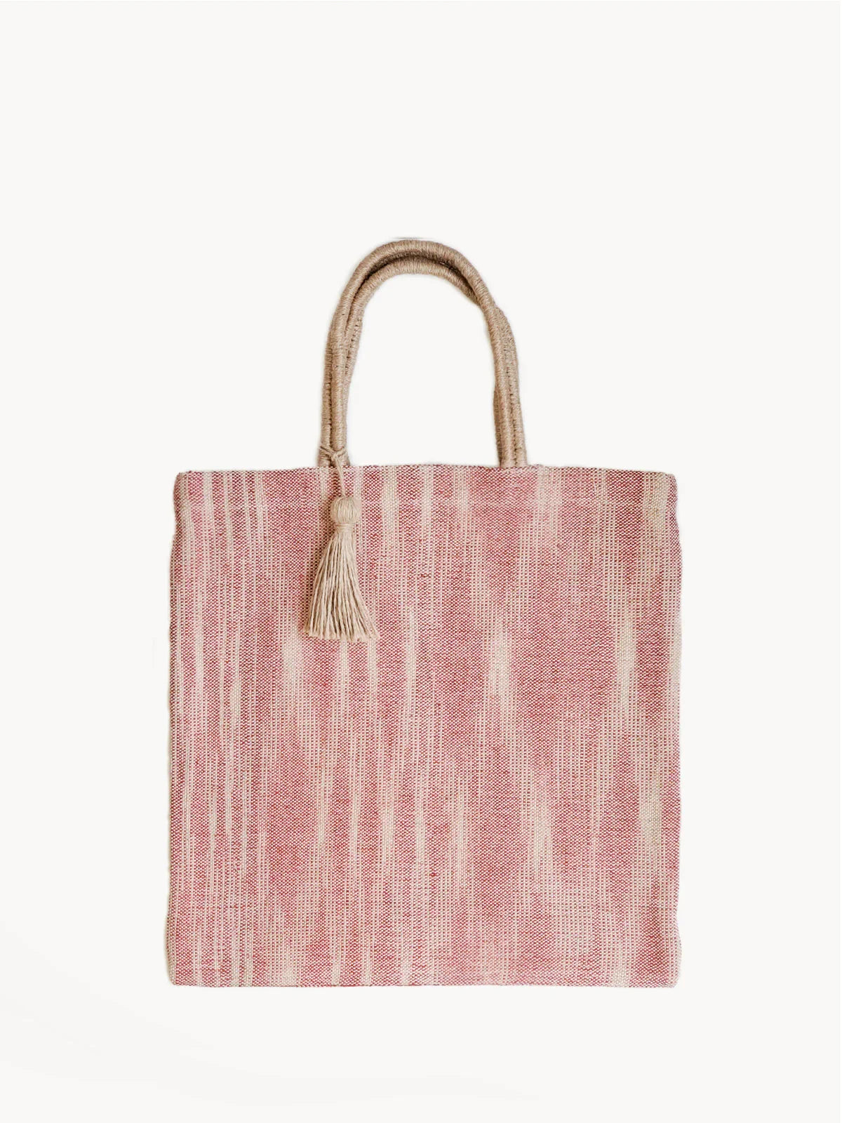 Red and beige woven jute tote bag with rope handles and tassel detail on white background