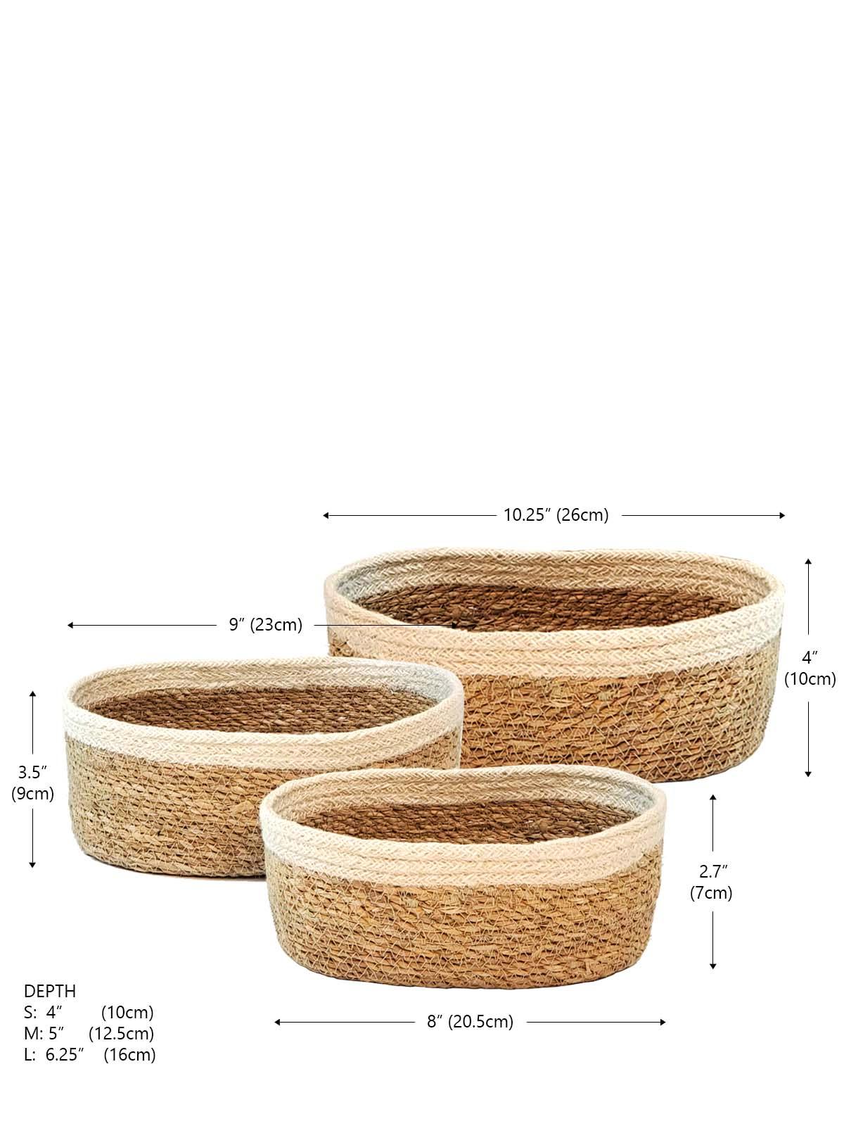 Set of three natural woven oval baskets with cream trim, various sizes, at Qu!rk Boutique.