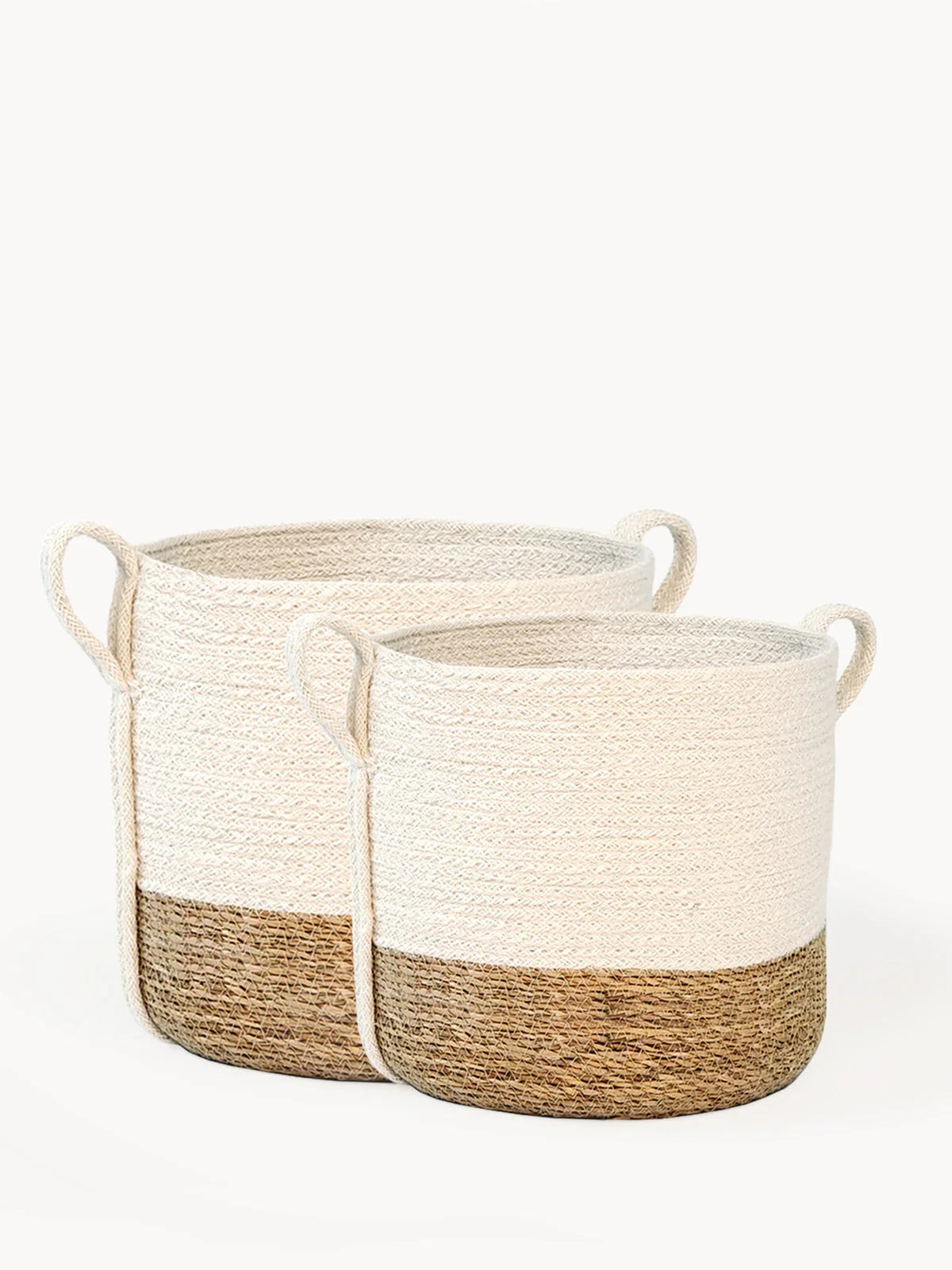 Set of two beige and brown woven storage baskets with side handles on white background