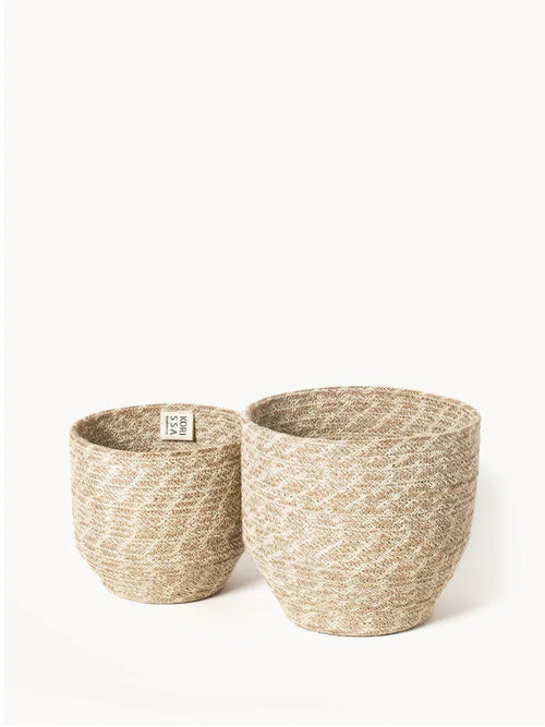 Two woven natural fiber baskets with subtle patterns, displayed on a white background at Qu!rk Boutique
