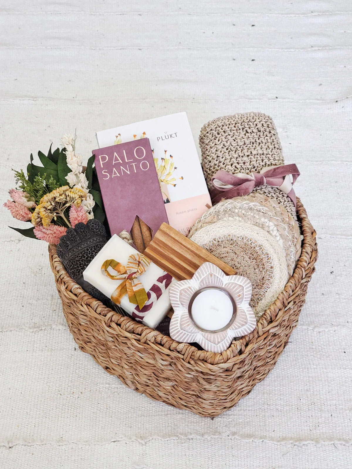 Woven basket gift set with dried flowers, Palo Santo, soap, coasters, candle, and knitted cloth