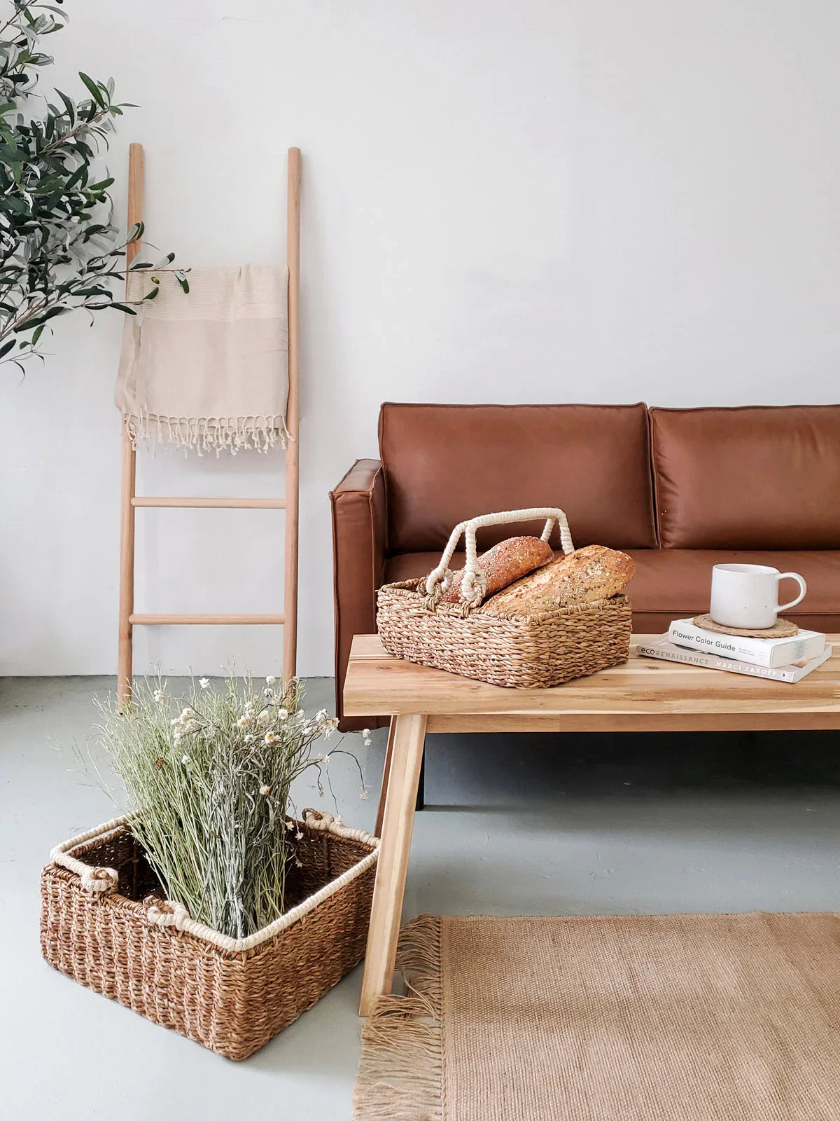 Handwoven storage basket with handle on wooden coffee table in modern, cozy living room decor