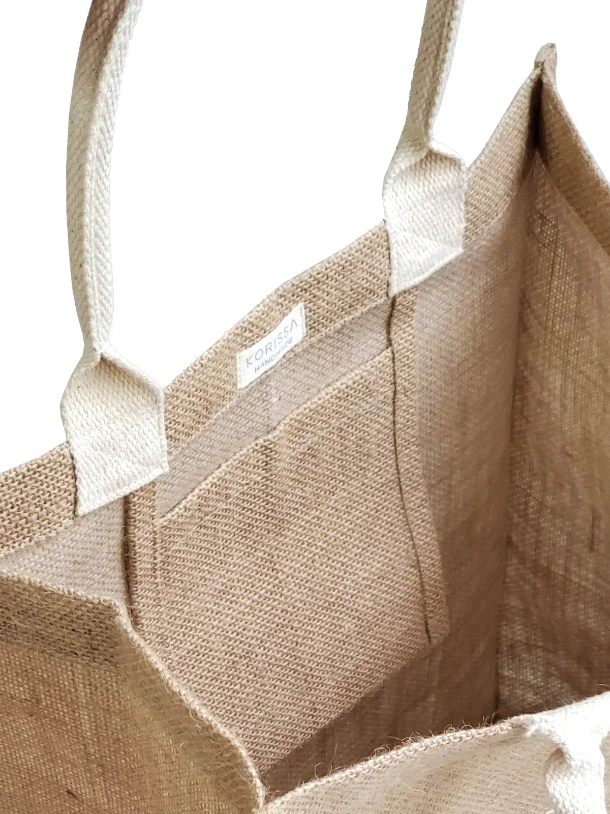 Close-up of natural fiber market bag with white handles and inner label, eco-friendly reusable tote