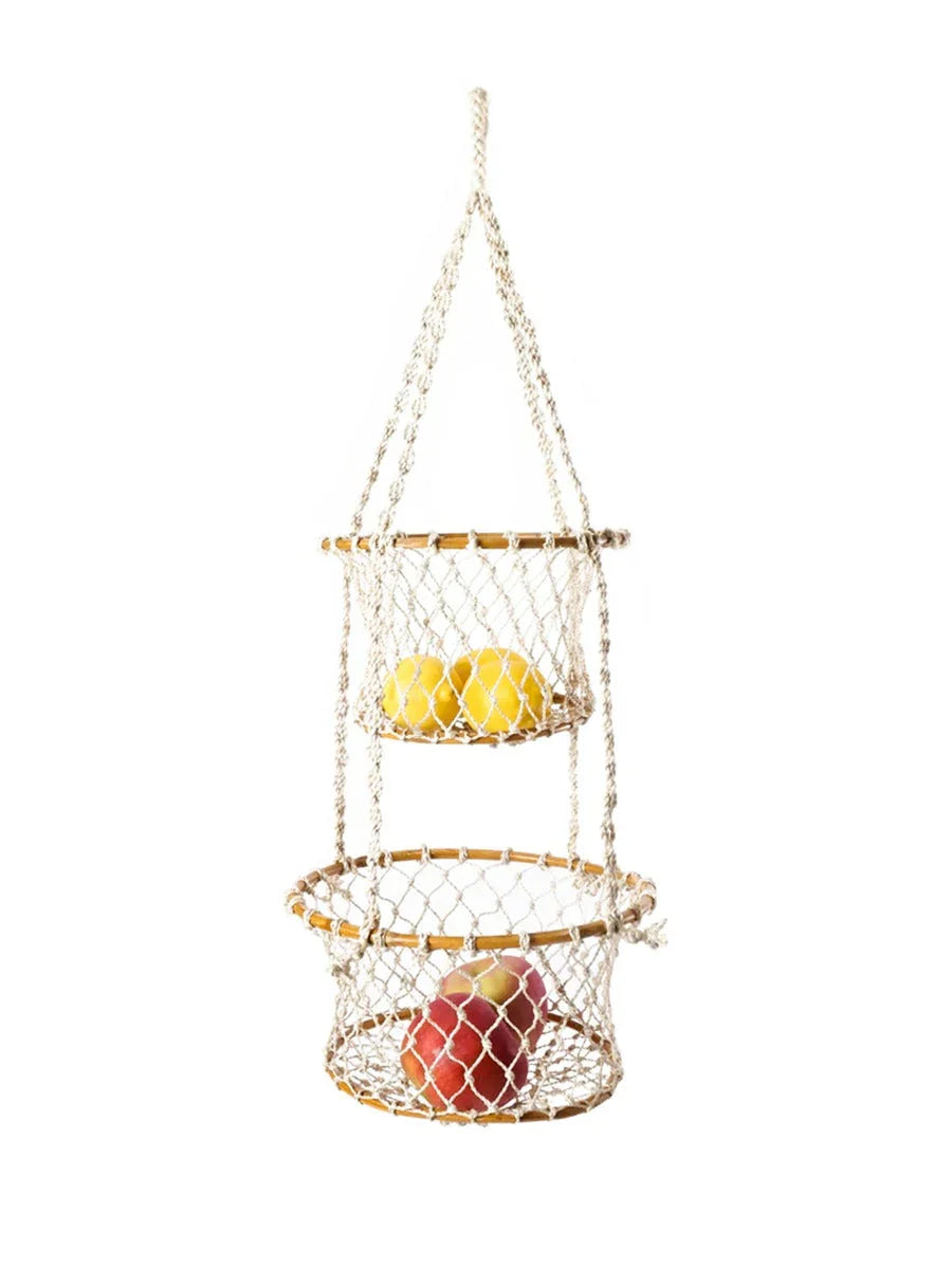 Two-tier hanging fruit basket made of cotton rope and wooden rings holding apples and lemons