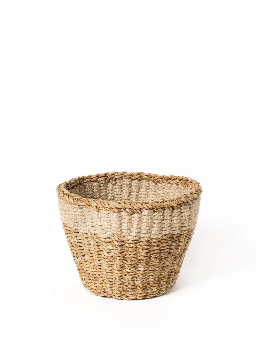 Handwoven natural seagrass planter basket on white background, eco-friendly home decor