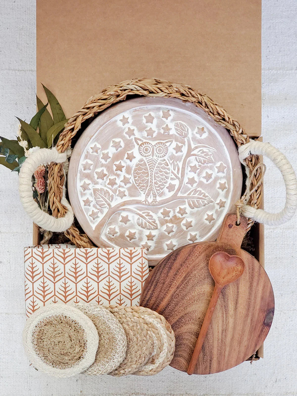 Gift box with owl carved breadwarmer, round wooden cutting board, coasters, and rustic packaging