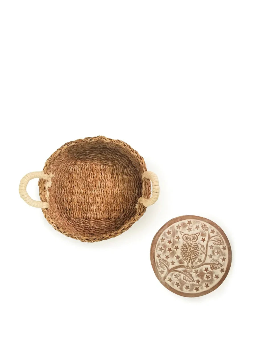 Round woven bread warmer basket with rope handles and owl design ceramic lid on white background