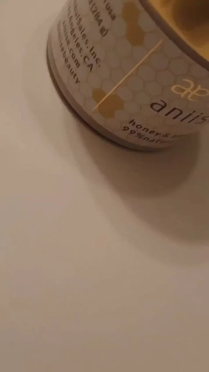 Close-up of honey and shea natural balm tin with hexagon pattern, Qu!rk Boutique gift.