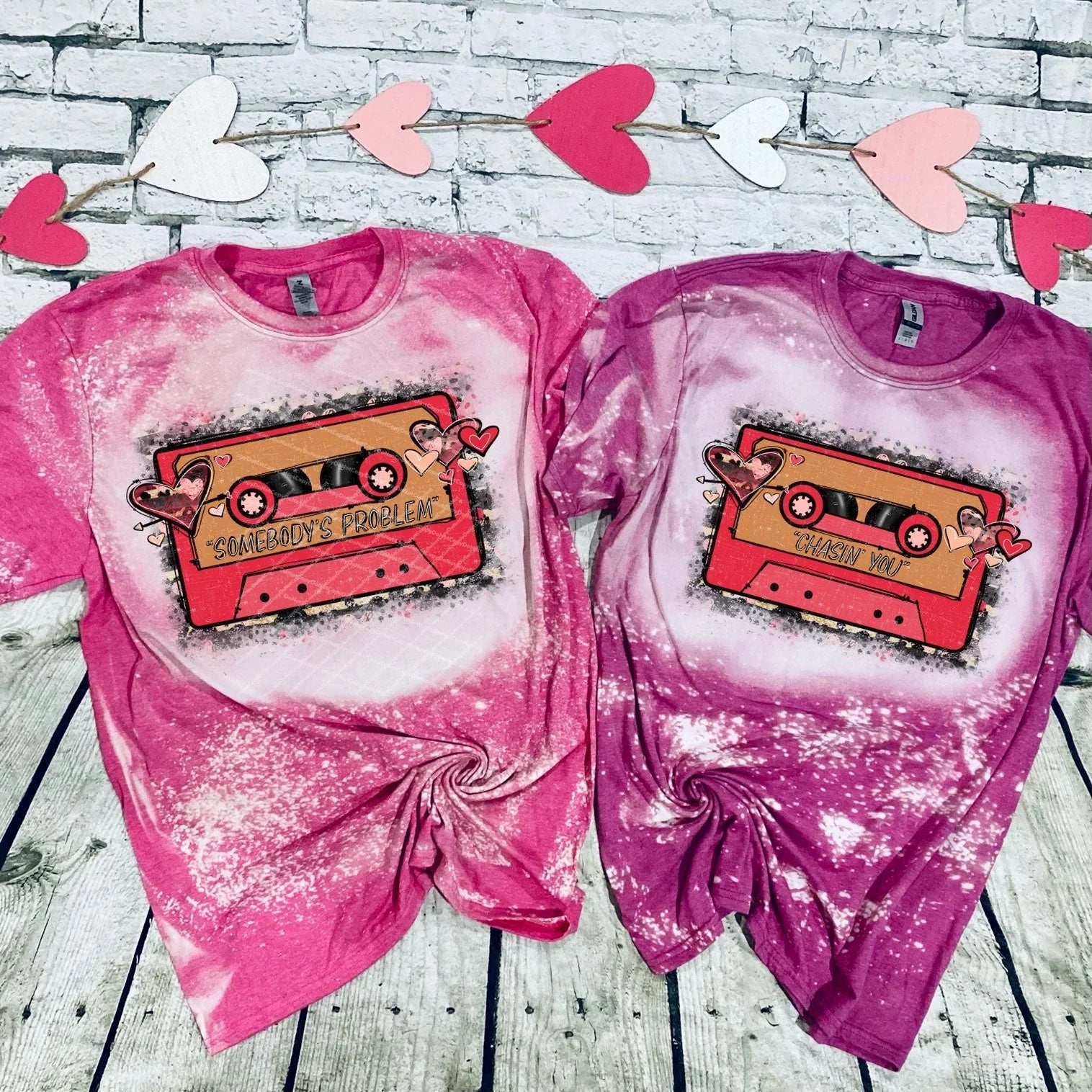 Two pink cassette-themed graphic t-shirts with heart accents, Qu!rk Boutique gift shop display