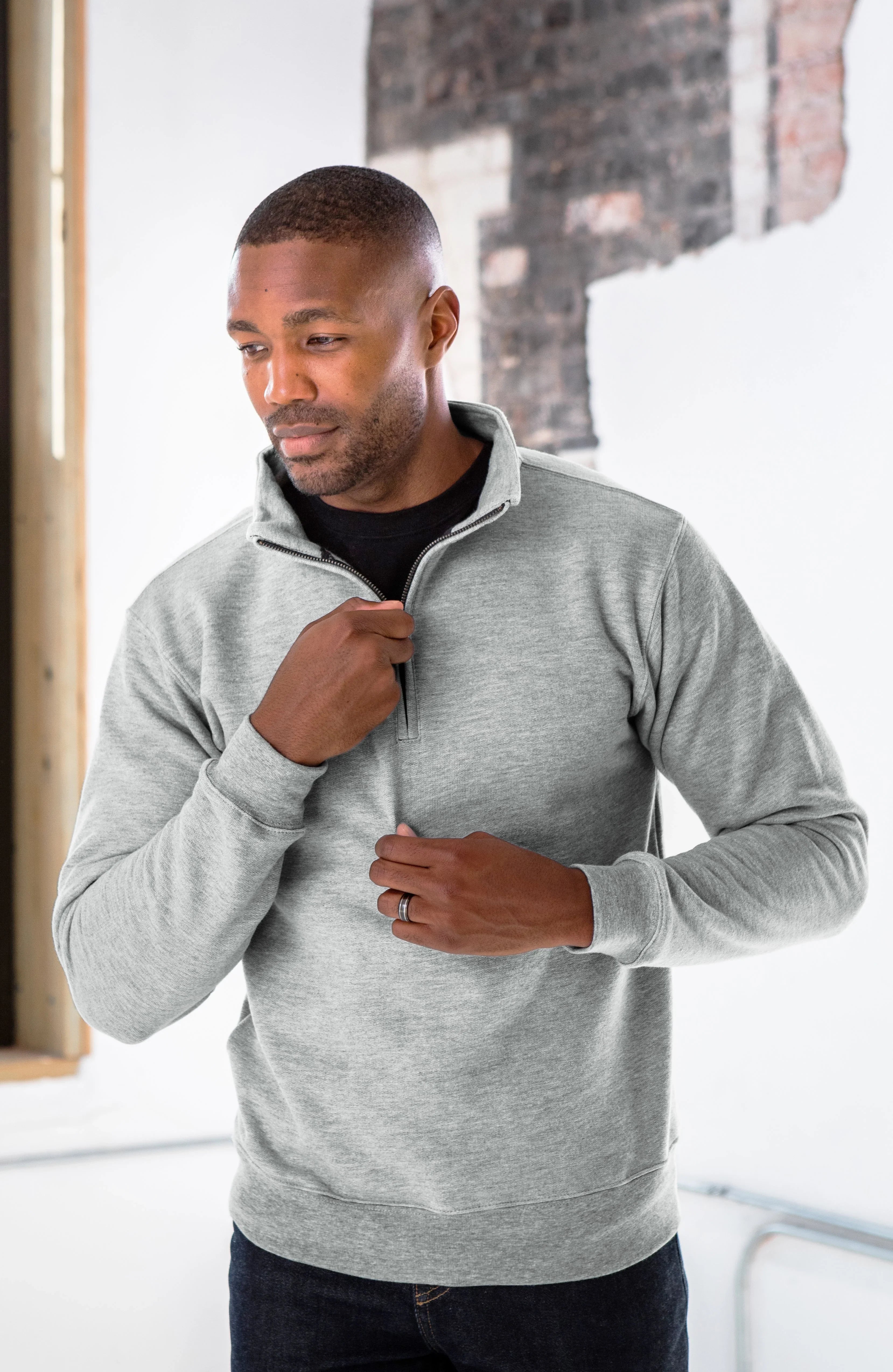 Man in light gray quarter-zip pullover from Qu!rk Boutique, modern minimalist style