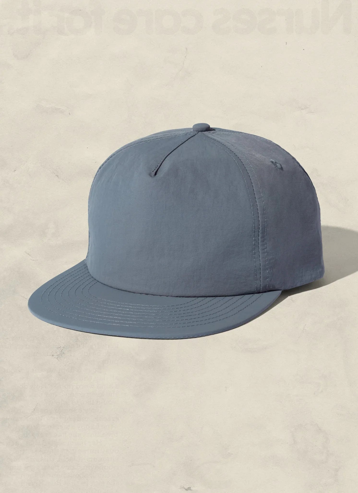 Minimalist blue baseball cap on cream background, Qu!rk Boutique cosmic couture accessory