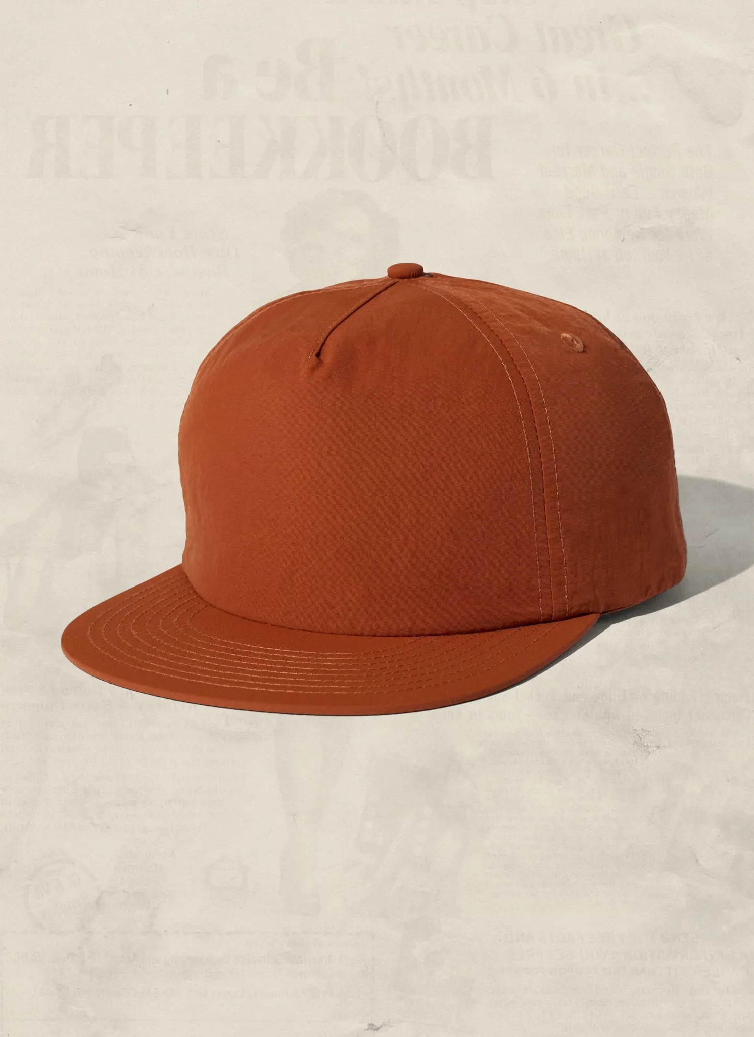 Rust orange baseball cap with curved brim, showcased on a neutral background at Qu!rk Boutique