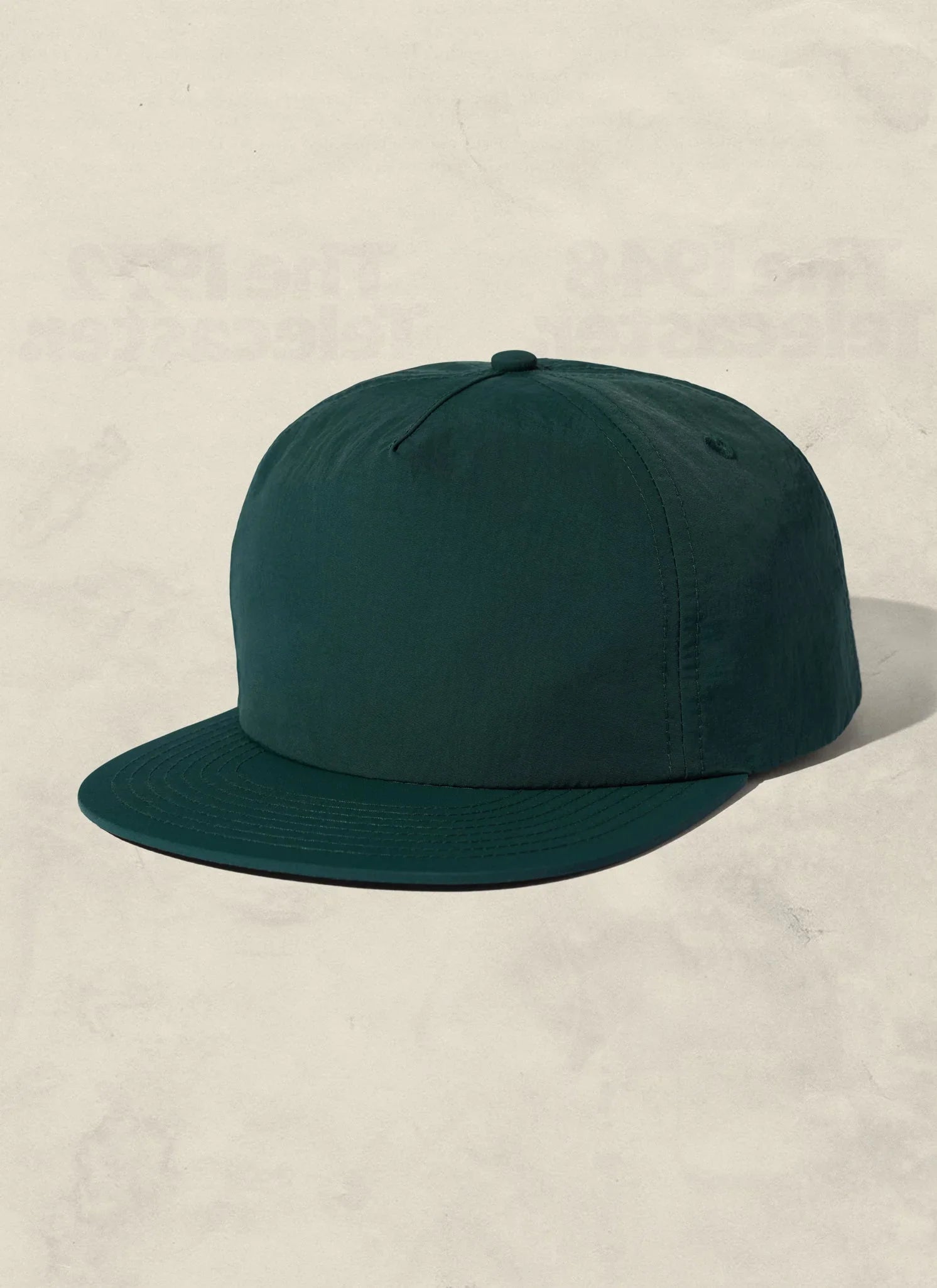 Minimalist dark green snapback hat on neutral background, Qu!rk Boutique sustainable fashion