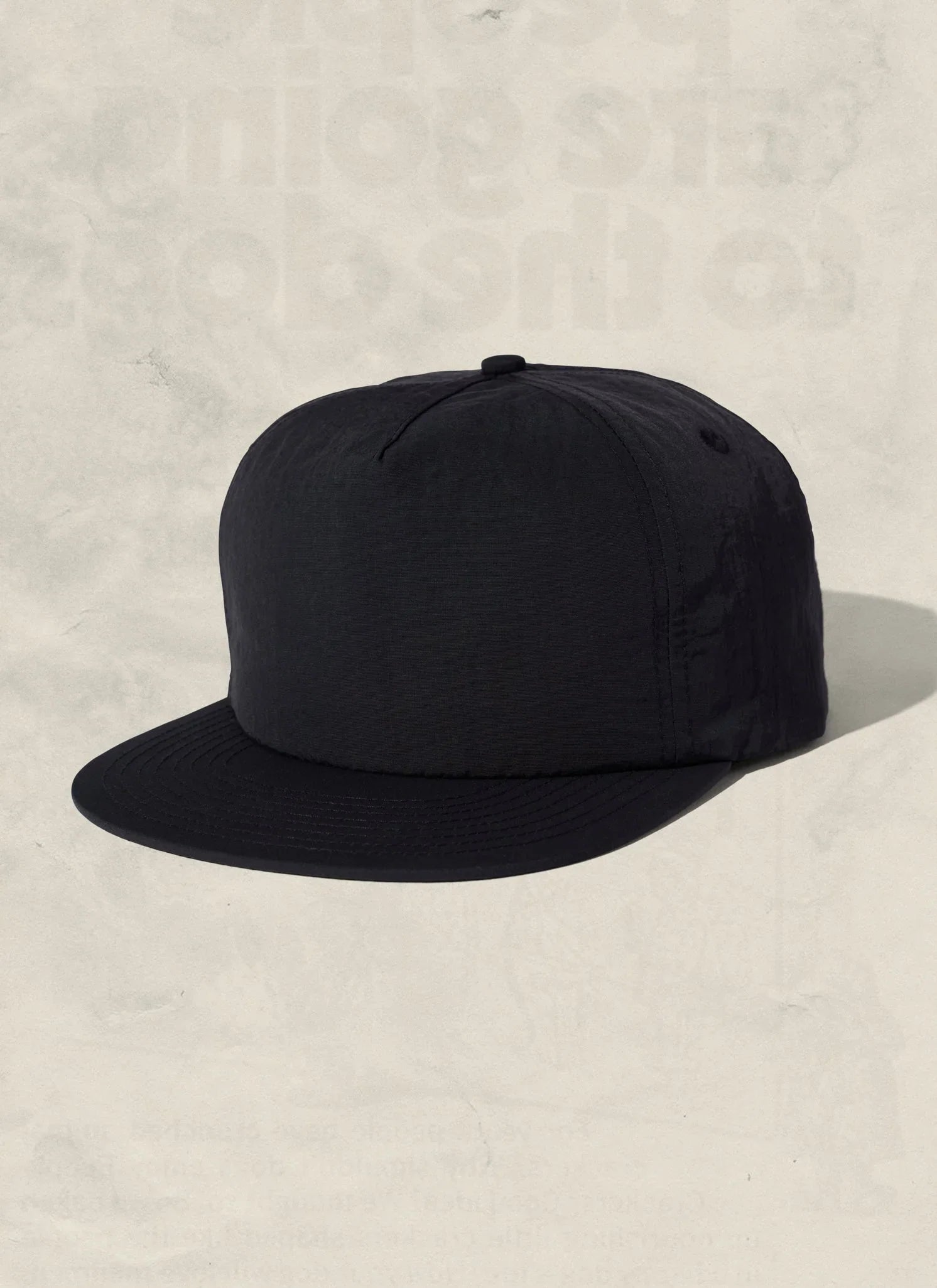 Minimalist black snapback hat on neutral background at Qu!rk Boutique