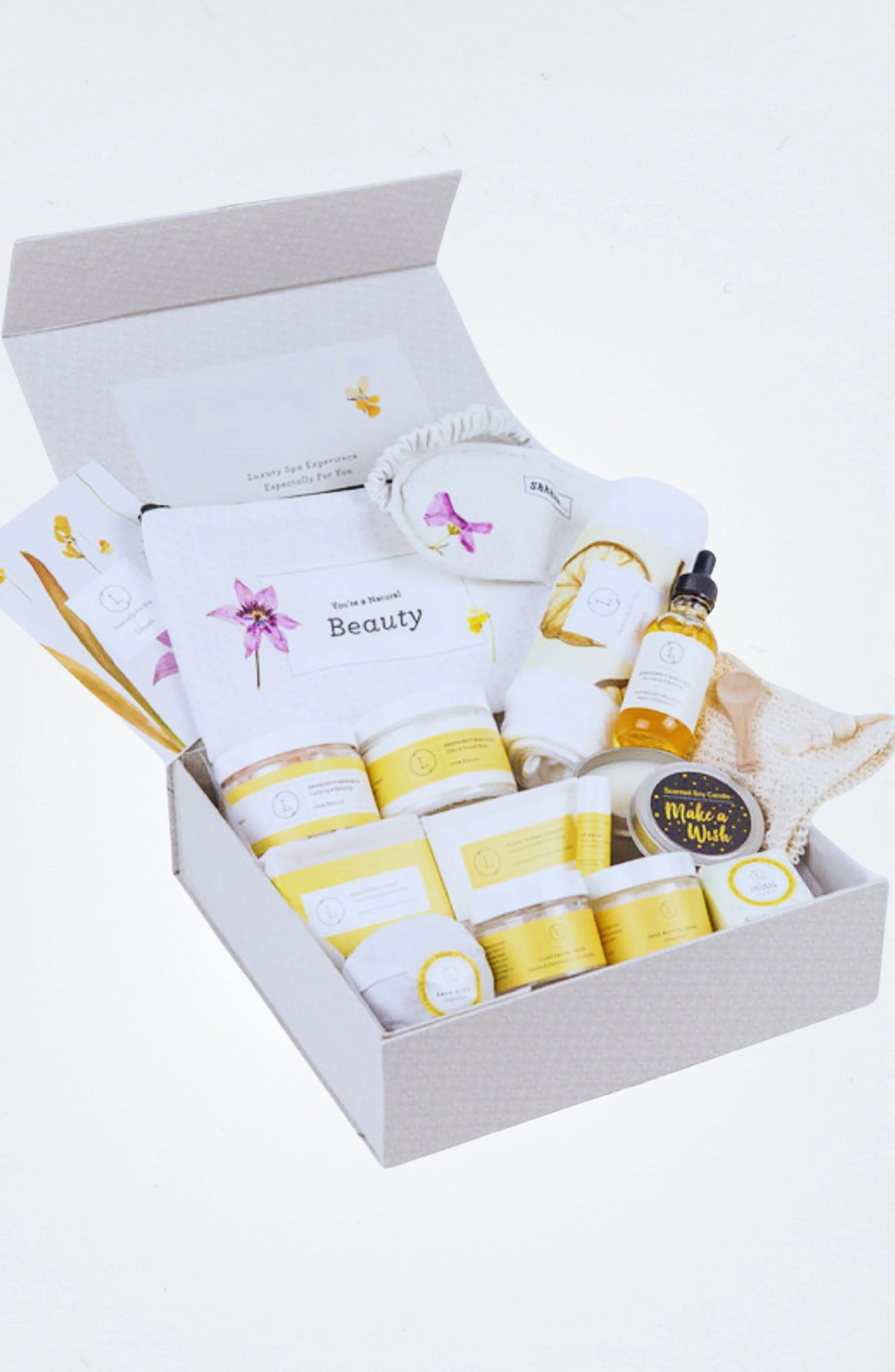 Luxury beauty spa gift box with yellow-labeled skincare products, towel, and accessories