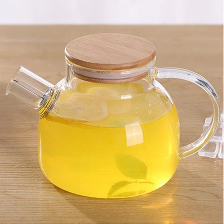 Glass teapot with bamboo lid filled with lemon herbal tea on wooden table, Qu!rk Boutique giftware