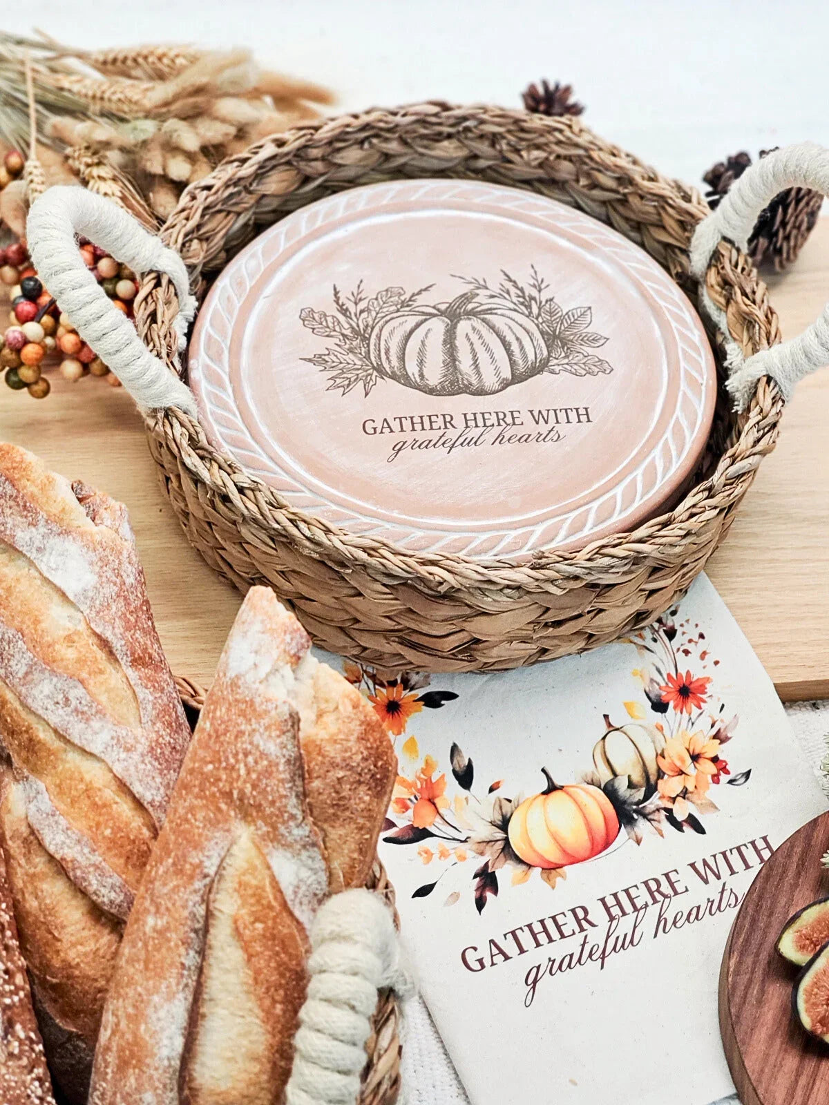 Woven basket with wooden plate featuring pumpkin and 'Gather here with grateful hearts' text, autumn decor