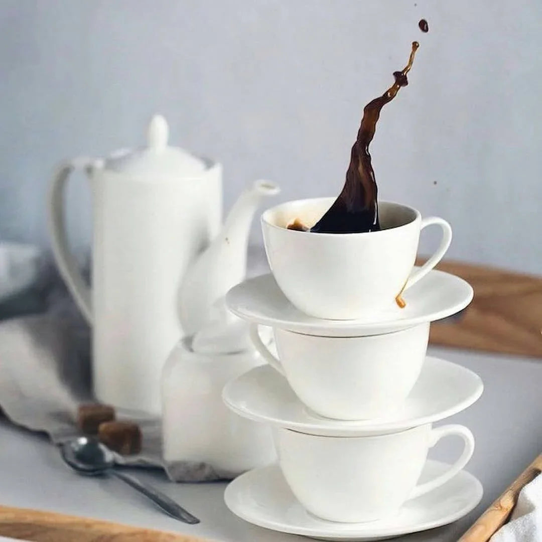 Stacked white teacups with coffee splash, elegant morning tea set, Qu!rk Boutique style