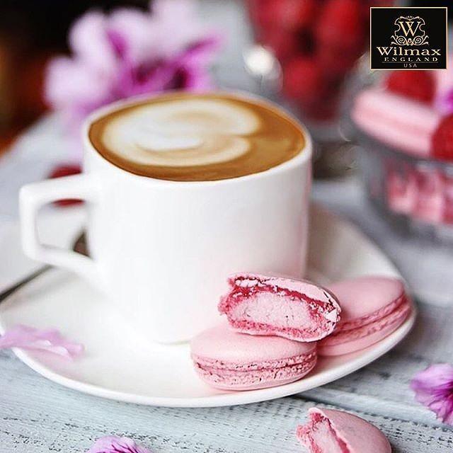 Latte in white mug with pink macarons on a plate, fresh and floral gift shop setting