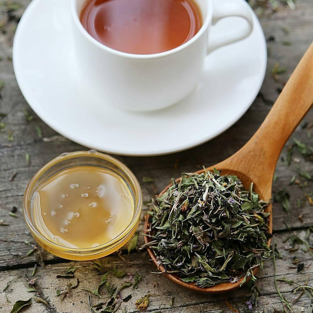 Herbal tea in white cup with dried leaves and honey on rustic wood, Qu!rk Boutique sustainable gift