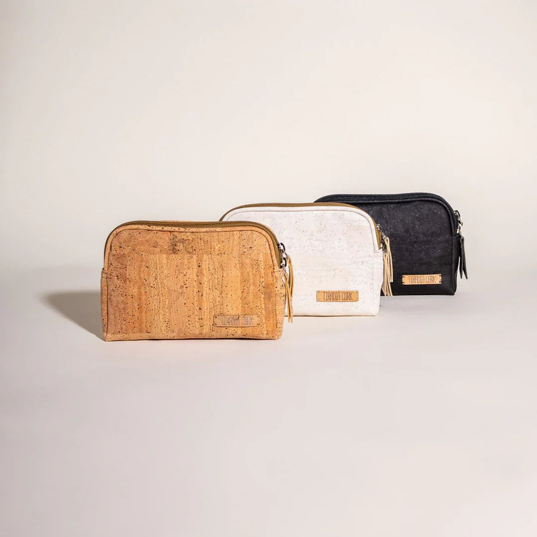 Three eco-friendly cork cosmetic bags in tan, white, and black from Qu!rk Boutique.