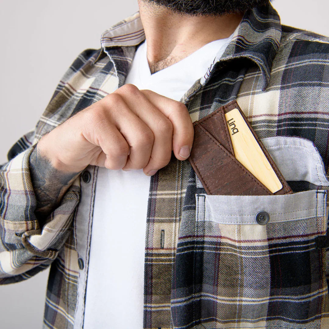Man in plaid shirt placing eco-friendly cork card holder with wooden card into chest pocket
