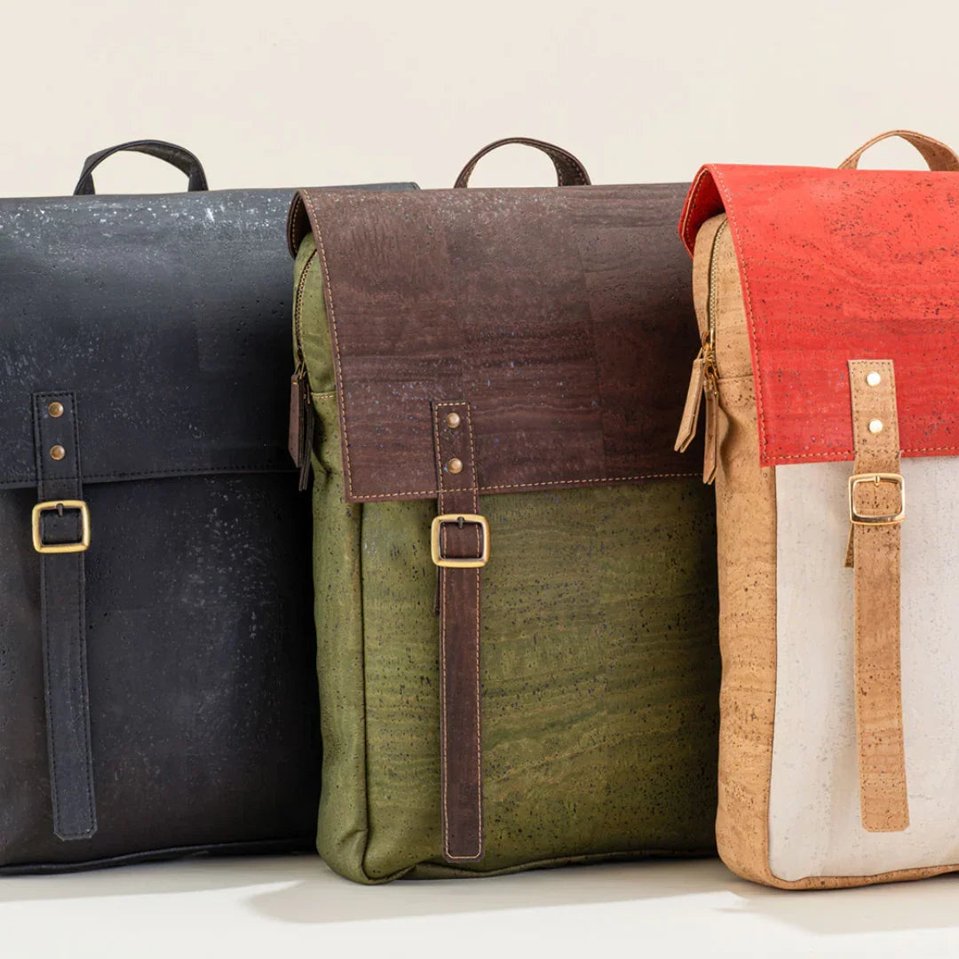 Three sustainable cork backpacks in black, olive green, and tan with red flap, displayed upright.