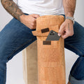 Person placing a smartphone in a cork yoga mat bag with front pocket, casual jeans style