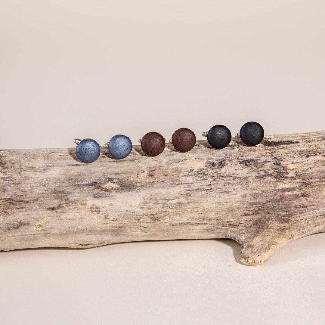 Handmade round stud earrings in blue, brown, and black on driftwood at Qu!rk Boutique
