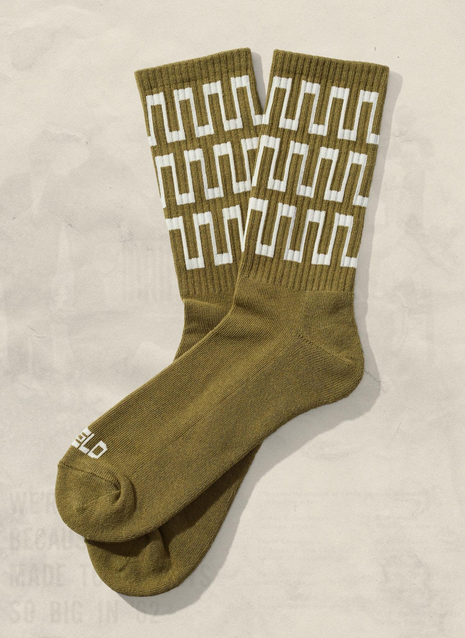 Olive green socks with bold white geometric pattern, artist-designed at Qu!rk Boutique