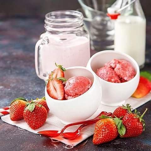 Strawberry sorbet and fresh strawberries in bowls, with a strawberry smoothie in a mason jar