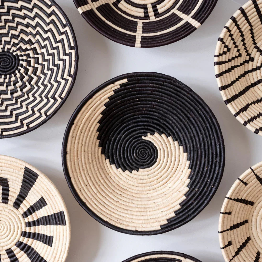 Handwoven black and natural baskets with bold geometric and spiral patterns on display at Qu!rk Boutique