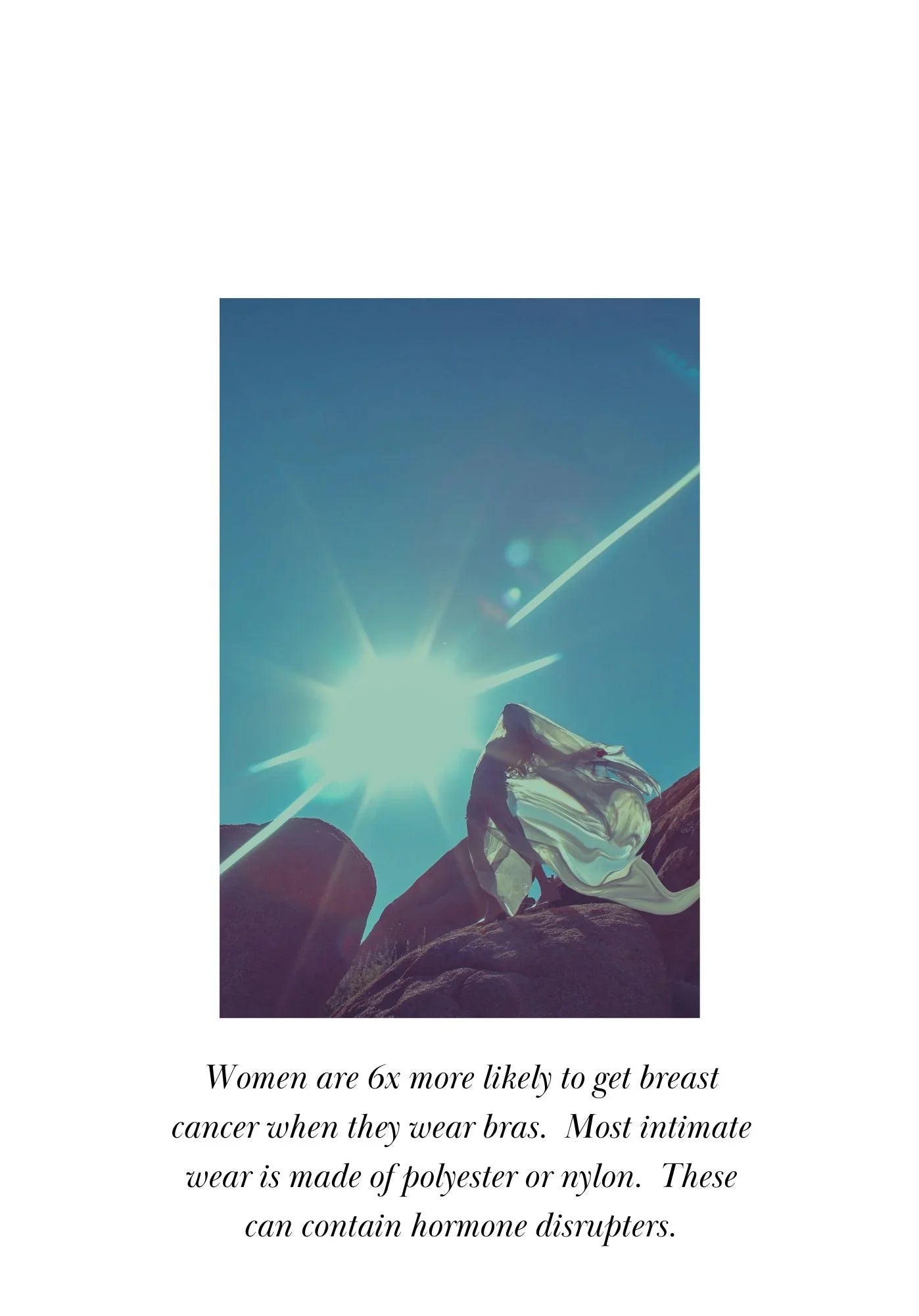 Woman in flowing dress standing on rocky terrain under bright sun with clear blue sky