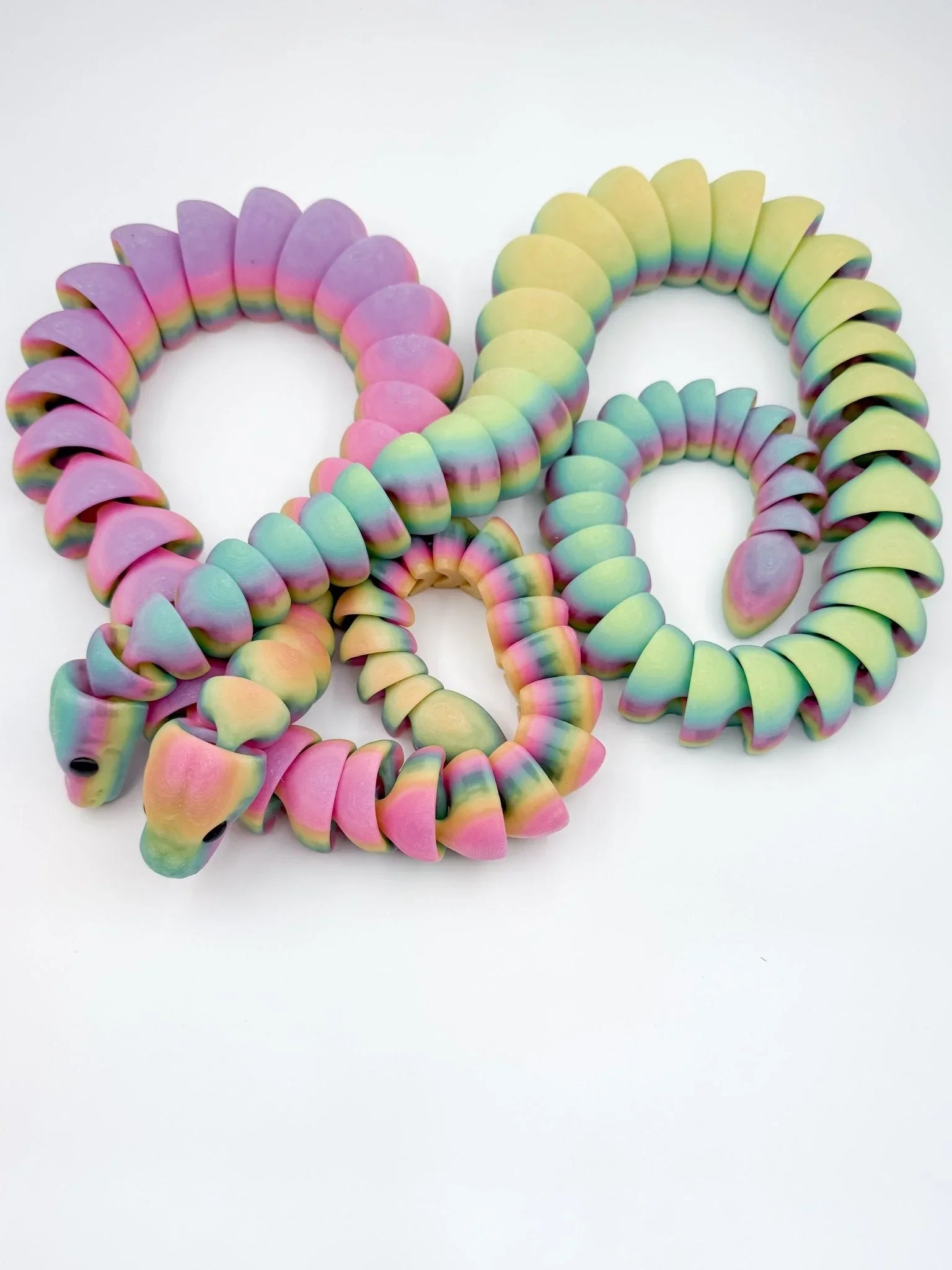 3D printed articulated rainbow snake fidget toy in pastel colors, glow in the dark, on white background