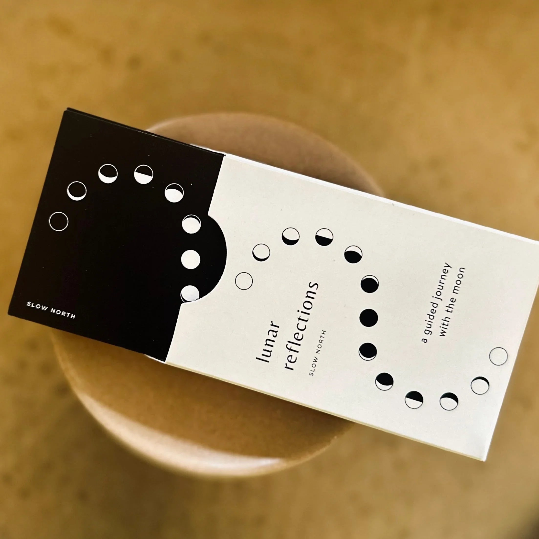 Lunar Reflections packaging by Slow North featuring moon phases design on black and white box