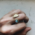 Hand wearing Qu!rk Boutique gold sun and Earth art ring, sustainable cosmic jewelry