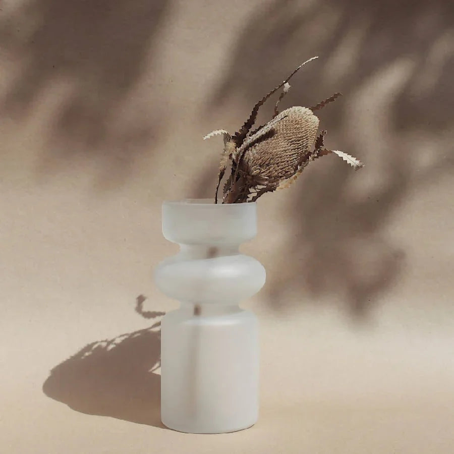 Modern frosted glass vase with dried foliage on neutral background, Qu!rk Boutique decor