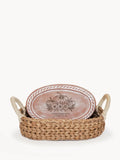 Woven basket with rope handles holding an oval wooden tray decorated with pumpkins and text