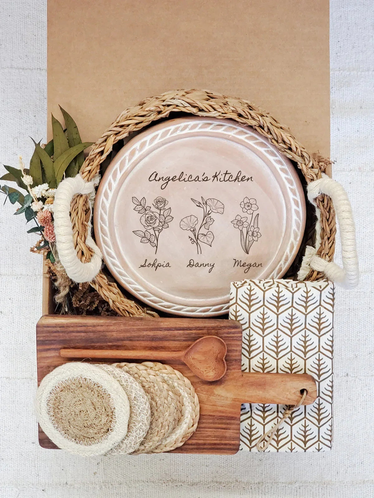 Personalized kitchen gift set with woven basket tray, engraved plate, wooden spoon, coasters, and floral napkin