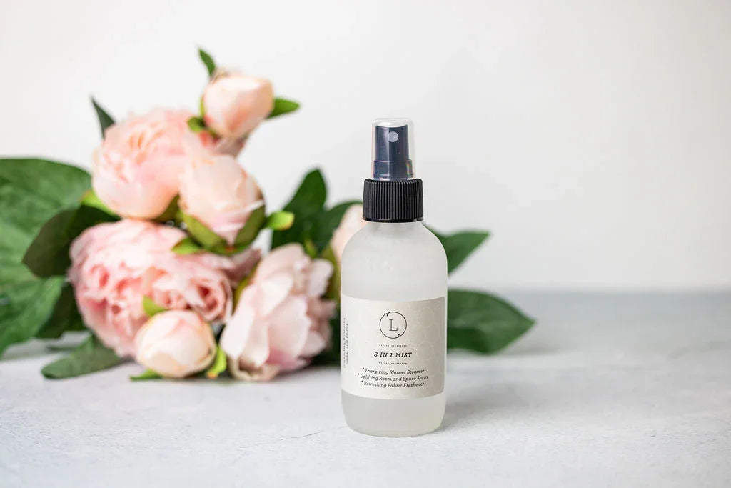 3 in 1 mist spray bottle on gray surface with pink flowers and green leaves in background