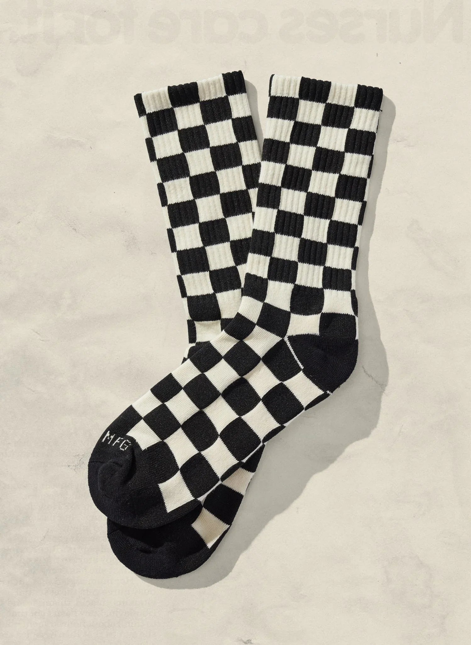 Black and white checkered socks on light background, boutique sustainable accessory
