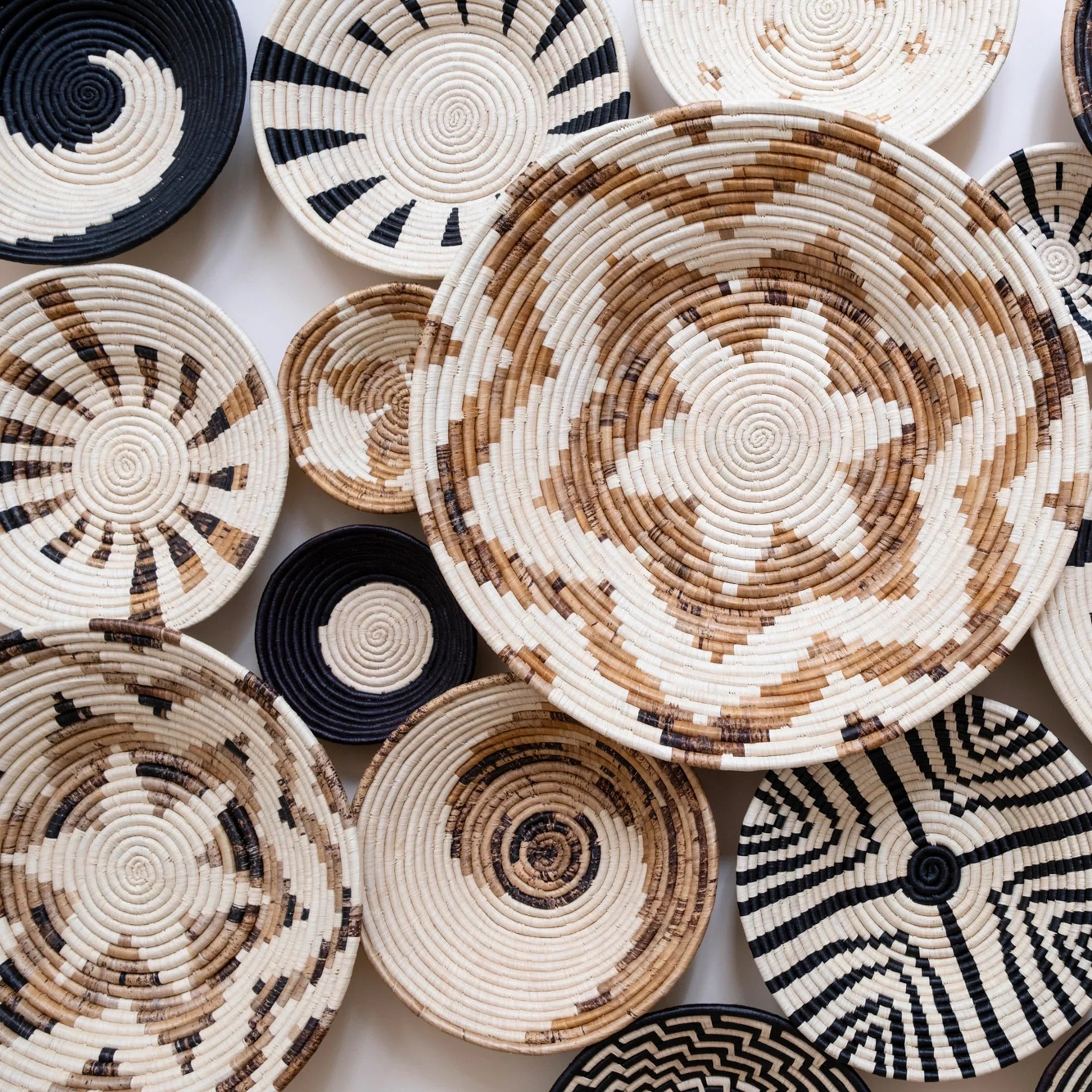 Handcrafted woven baskets with geometric patterns in natural and black tones from Qu!rk Boutique